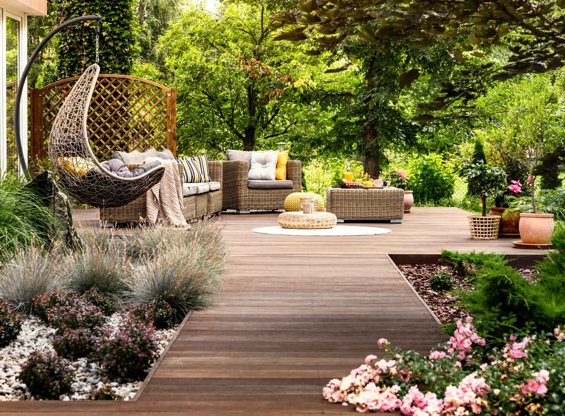 Terrassensteg mit Holzdielen führt zu Plattform in Garten auf der Gartenmöbel stehen